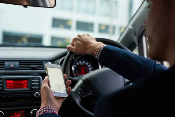 Jag har kontakt med honom på pendlingen. Beskuren bild av en oigenkännlig affärsman som använder sin mobiltelefon under körning. — Stockfoto