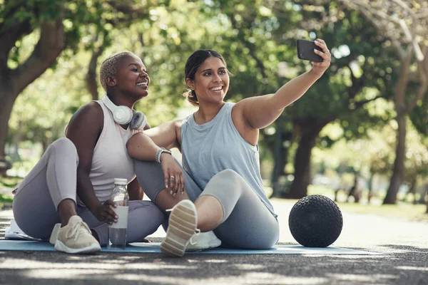 Lets make some memories. Shot of two young female friends taking a break during their workout to take selfies. — ストック写真