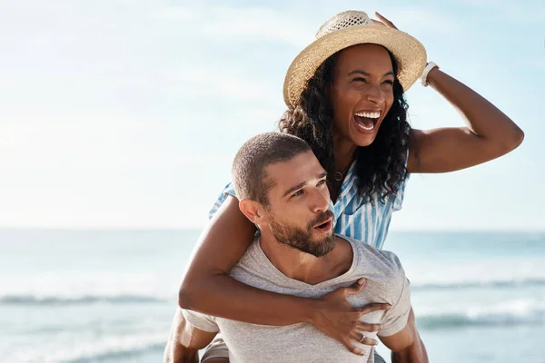 Kollar in sevärdheterna runt havet. Skjuten av en ung man grisar backa sin flickvän på stranden. — Stockfoto