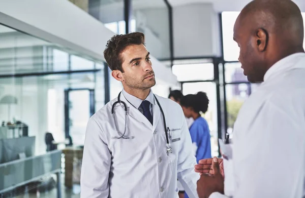 Doubler l'expertise médicale. Prise de vue de deux médecins en train de discuter dans un hôpital. — Photo