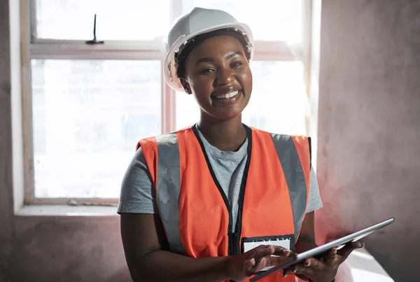 Het zit niet in mijn gereedschapskist, maar het is net zo belangrijk. Foto van een jonge vrouw met behulp van een digitale tablet tijdens het werken op een bouwplaats. — Stockfoto