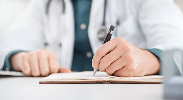 La recherche et la planification sont les premières. Gros plan d'un médecin méconnaissable écrivant des notes dans un cabinet médical. — Photo