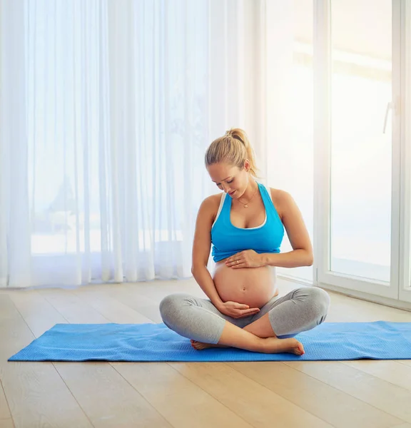 Annen seni seviyor küçüğüm. Evde egzersiz paspasında çalışan hamile bir kadının fotoğrafı.. — Stok fotoğraf