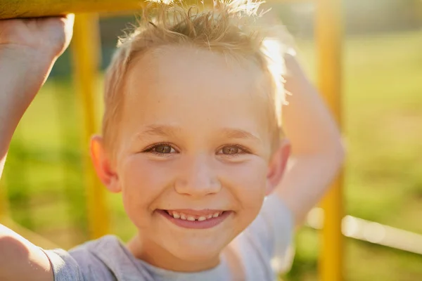 Veselé dětství. Portrét usměvavého chlapečka hrajícího si na džungli v parku. — Stock fotografie