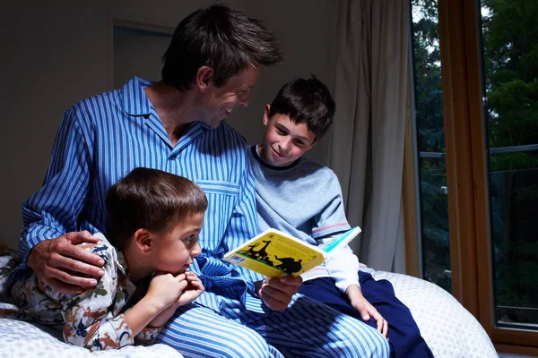 Un conte avant le coucher - Family Bonding. Un père lisant à ses deux fils au coucher - Copyspace. — Photo