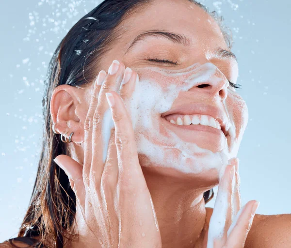 청결 함은 확신을 가지고 환하게 빛나게 할 것이다. 스튜디오에서 한 젊은 여자가 푸른 배경에 샤워를 하면서 얼굴을 씻고 있는 장면. — 스톡 사진