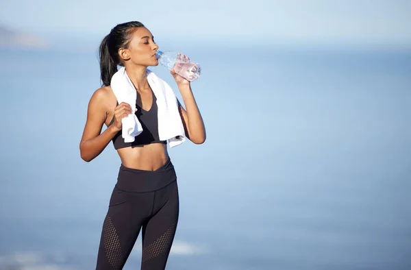 Βεβαιωθείτε ότι θα μείνετε ενυδατωμένοι πριν και μετά την προπόνηση σας. Shot of a sporty νεαρή γυναίκα πόσιμο νερό κατά την άσκηση σε εξωτερικούς χώρους. — Φωτογραφία Αρχείου