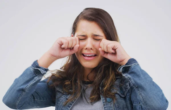 Non è la fine del mondo. Studio colpo di una giovane donna che piange mentre in piedi su uno sfondo grigio. — Foto Stock