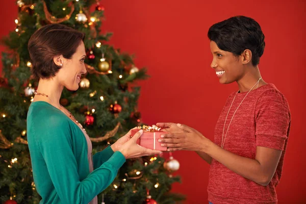 Un regalo para mi mejor amiga. Fotografía de dos mujeres jóvenes intercambiando regalos en Navidad. —  Fotos de Stock