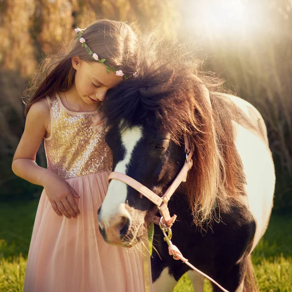 Toutes les petites filles rêvent. Tourné d'une jolie petite fille jouant avec son poney à l'extérieur. — Photo