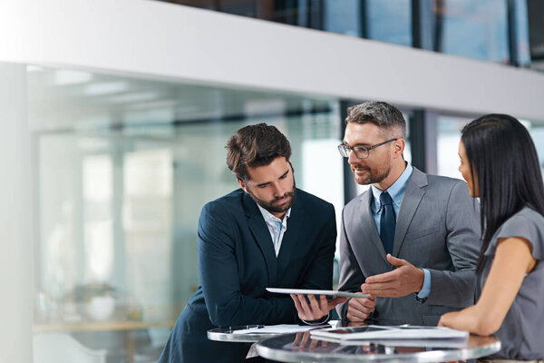 Sometimes you need a fresh perspective. Cropped shot of a group of businesspeople looking over a digital tablet in the office.