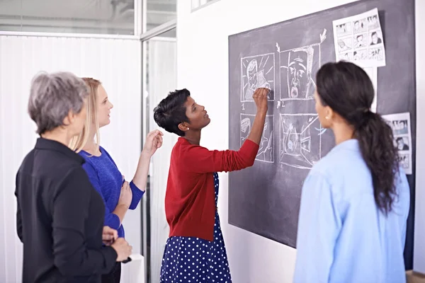 Finalizando sua ilustração. Tiro de um grupo de designers do sexo feminino que trabalham em um quadro-negro em seu escritório. — Fotografia de Stock