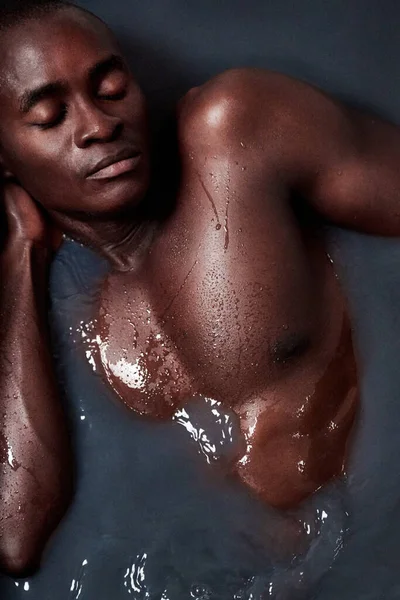 Aussi mignon que mignon. Tourné d'un beau jeune homme immergé dans un bain rempli d'eau sombre. — Photo