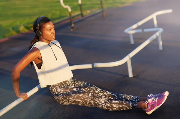 Fortaleciendo su cuerpo. Una joven haciendo ejercicio al aire libre. —  Fotos de Stock