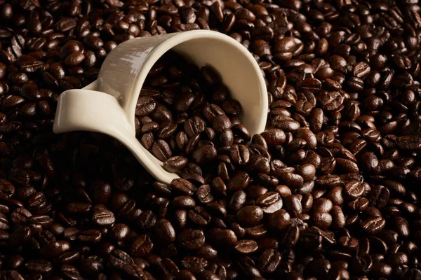 Cada haba está llena de energía. Primer plano de una taza en una pila de granos de café. — Foto de Stock