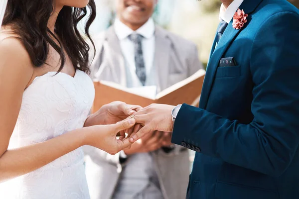 Moge deze ring onze levenslange band verzegelen. Gehakt schot van een onherkenbare bruid glijdt een ring aan haar bruidegoms vinger terwijl ze voor het altaar staan op hun trouwdag. — Stockfoto