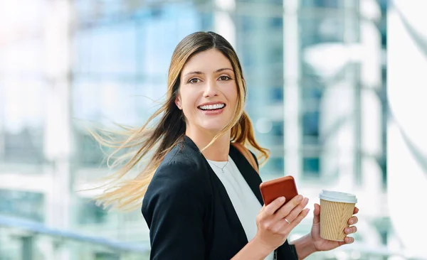 Shes always on the go. Cropped portrait of an attractive young businesswoman smiling while walking through a modern office. — ストック写真