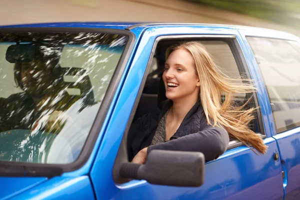 Na drodze. Młoda kobieta czuje wiatr we włosach przez otwarte okno samochodu. — Zdjęcie stockowe