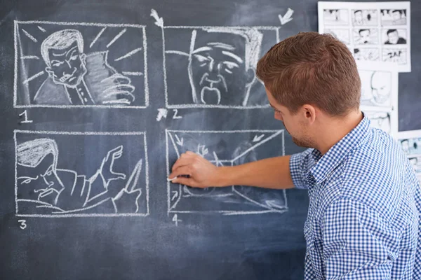 彼の次の撮影の計画。事務所の黒板に絵を描く青年. — ストック写真