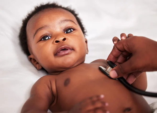 Låt oss lyssna på ditt lilla hjärta. Skjuten av en liten bebis på en kontroll med en läkare på en klinik. — Stockfoto