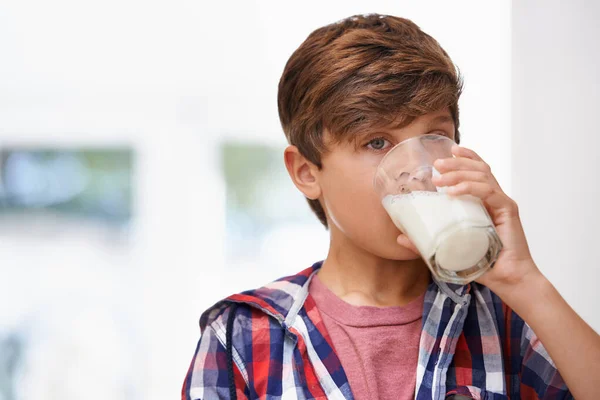 Ah... köstlich. Ein kleiner Junge trinkt ein Glas Milch. — Stockfoto
