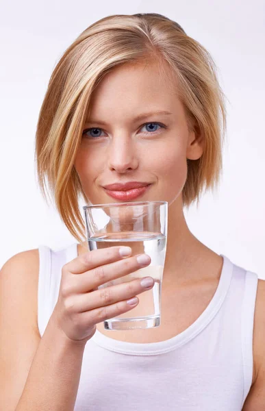 Erfrischend frei. Studioporträt einer schönen jungen Frau mit einem Glas Wasser. — Stockfoto