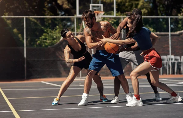 Můžete hrát basketbal s hravým nebo soutěžním duchem. Zastřelen skupinou sportovních mladých lidí, kteří hrají basketbal na sportovním hřišti. — Stock fotografie
