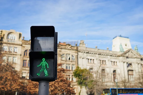 Dags att gå. Skott av en fotgängare trafikljus med stadsbyggnader som ligger i bakgrunden utanför under dagen. — Stockfoto