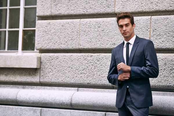 El estilo de vida de un hombre de negocios. Retrato de un hombre de negocios guapo en un traje parado fuera de un edificio de la ciudad. —  Fotos de Stock