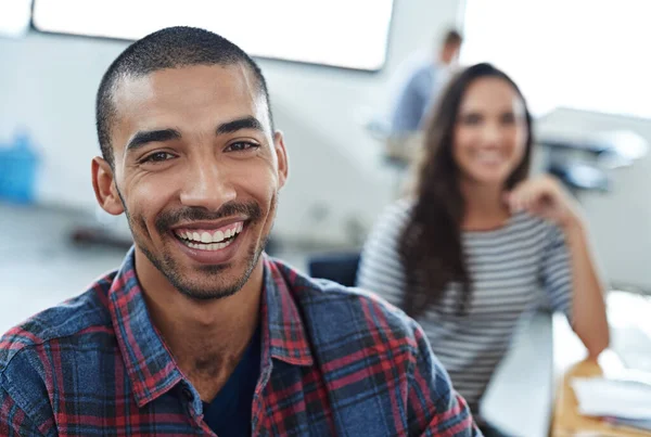 Hacer de la creatividad un trabajo. Retrato de dos compañeros de trabajo sonrientes sentados en sus computadoras. — Foto de Stock