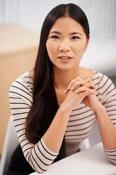 Seguro que tendrá éxito. Retrato de una joven empresaria asiática segura sentada en su escritorio. —  Fotos de Stock