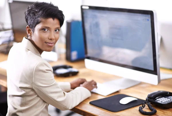Hon är en flitig arbetare. Porträtt av en attraktiv affärskvinna som arbetar på en stationär dator. — Stockfoto