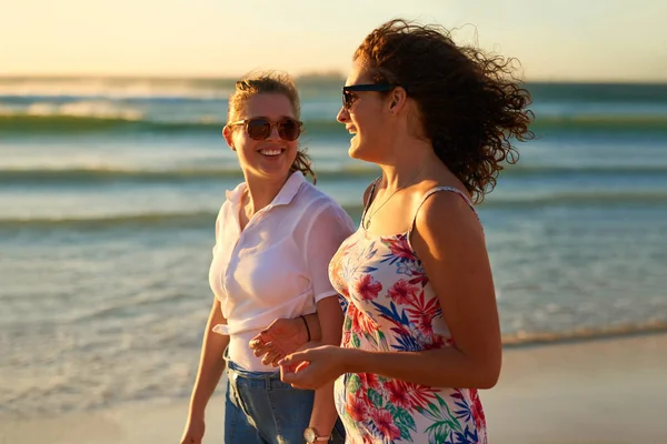 Qui n'aime pas une journée à la plage avec bestie. Plan recadré de deux jolies jeunes copines en train de bavarder tout en se promenant sur la plage. — Photo