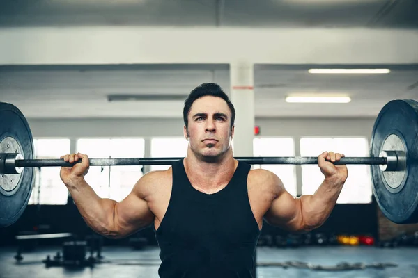 Levantar no es un acto, sino un hábito. Tiro de un hombre levantando pesas en el gimnasio. — Foto de Stock