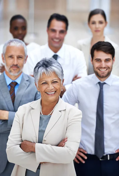 Verificación de excelencia corporativa. Retrato de una mujer de negocios sonriente rodeada por un grupo de sus colegas. — Foto de Stock