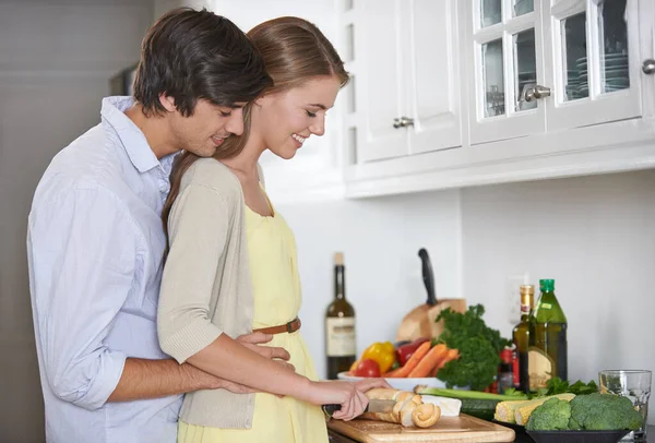 Liebevoll Abendessen zubereiten. Aufnahme eines jungen Paares in ihrer Küche beim gemeinsamen Zubereiten des Abendessens. — Stockfoto