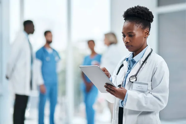 A investigar melhor as suas observações. Tiro de um jovem médico usando um tablet digital em um hospital. — Fotografia de Stock