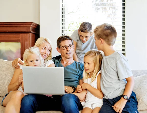 Dzielenie się cyfrowym światem jako rodzina. Zdjęcie rodziny używającej laptopa razem w domu. — Zdjęcie stockowe