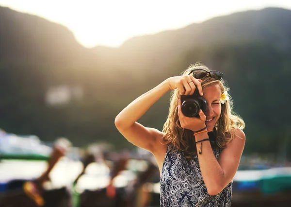 No te pierdas ni un momento. Retrato de una joven tomando fotos con su cámara en la playa. — Foto de Stock