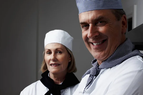 Close-up van een vrolijke mannelijke en vrouwelijke chef-koks die glimlachen. Close-up portret van een gelukkige mannelijke en vrouwelijke koks glimlachend. — Stockfoto