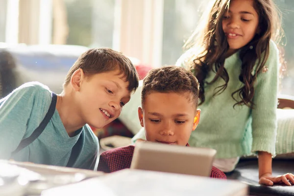 Manteniendo a los niños ocupados con la tecnología. Fotografía de niños pequeños usando una tableta digital juntos en casa. —  Fotos de Stock