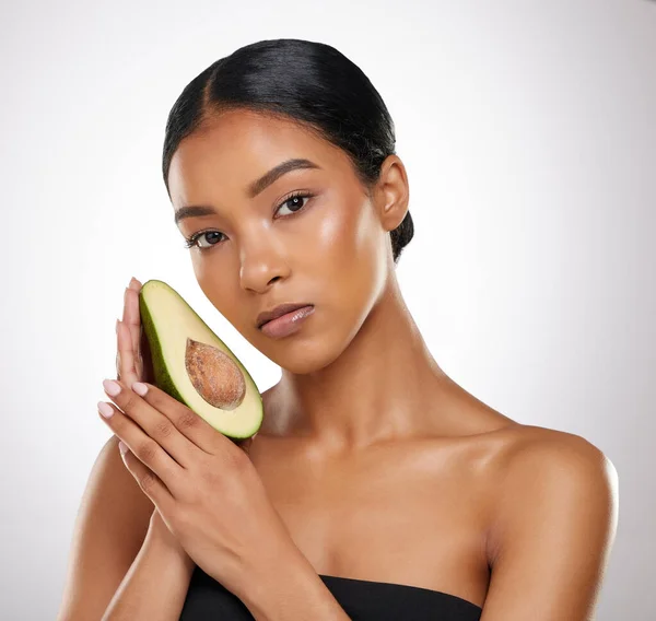 Avocado 's zijn mijn beste vriendin. Studio portret van een aantrekkelijke jonge vrouw poseren met een halve avocado tegen een grijze achtergrond. — Stockfoto