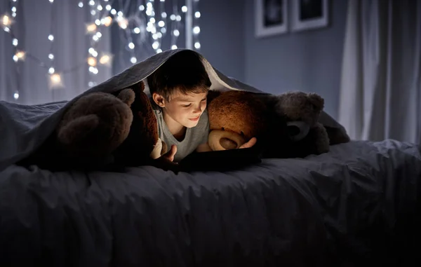 Troppo curioso per dormire. Girato di un adorabile ragazzino che usa un tablet digitale a letto di notte. — Foto Stock