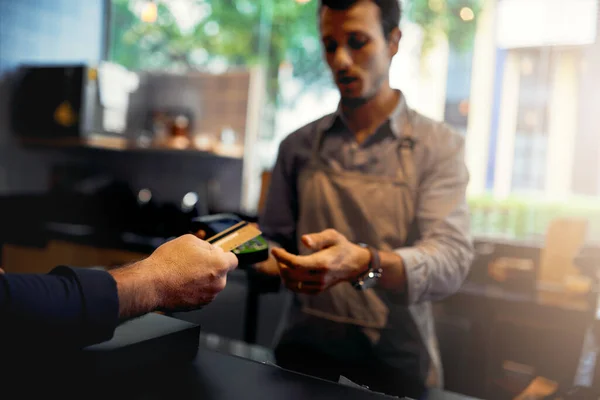 Сплачувати. Обрізаний знімок невизначеного клієнта-чоловіка, що робить оплату кредитною карткою в кав'ярні . — стокове фото