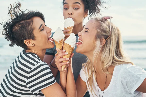 Po zmrzlině se holky zblázní. Vystřižený záběr tří přátel jíst led, zatímco venku na promenádě. — Stock fotografie