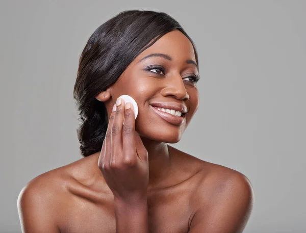 Its all part of her beauty regime. Cropped shot of a beautiful young woman using a cotton pad to cleanse her skin. — Stock Photo, Image