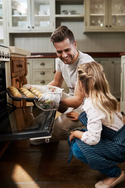 Je muffins kwamen er zo perfect uit. Gehakt schot van een jong meisje en haar vader bakken in huis. — Stockfoto