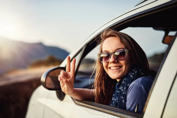 Wyluzuj. Portret młodej kobiety z tabliczką znamionową siedzącej w samochodzie. — Zdjęcie stockowe