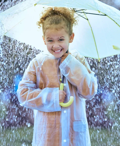 Esto es tan emocionante. Fotografía de una niña juguetonamente de pie bajo la lluvia sosteniendo su paraguas. — Foto de Stock