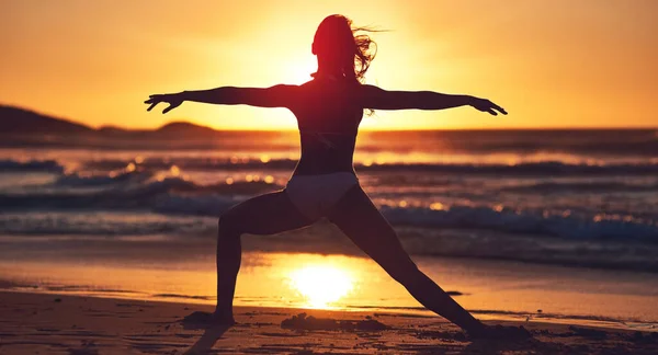要安宁，不要支离破碎。在海滩上练习瑜伽的年轻女子的轮廓. — 图库照片